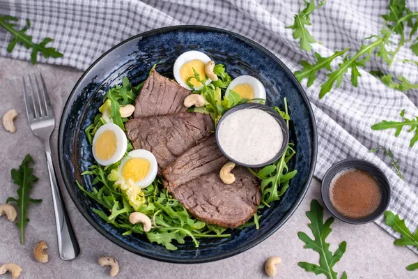 A bowl with slices of meat, egg and rocket, KETO program